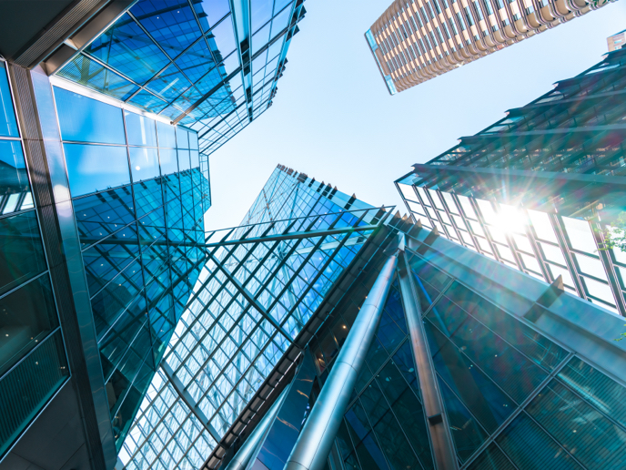 Looking up view of a group of tall buildings.